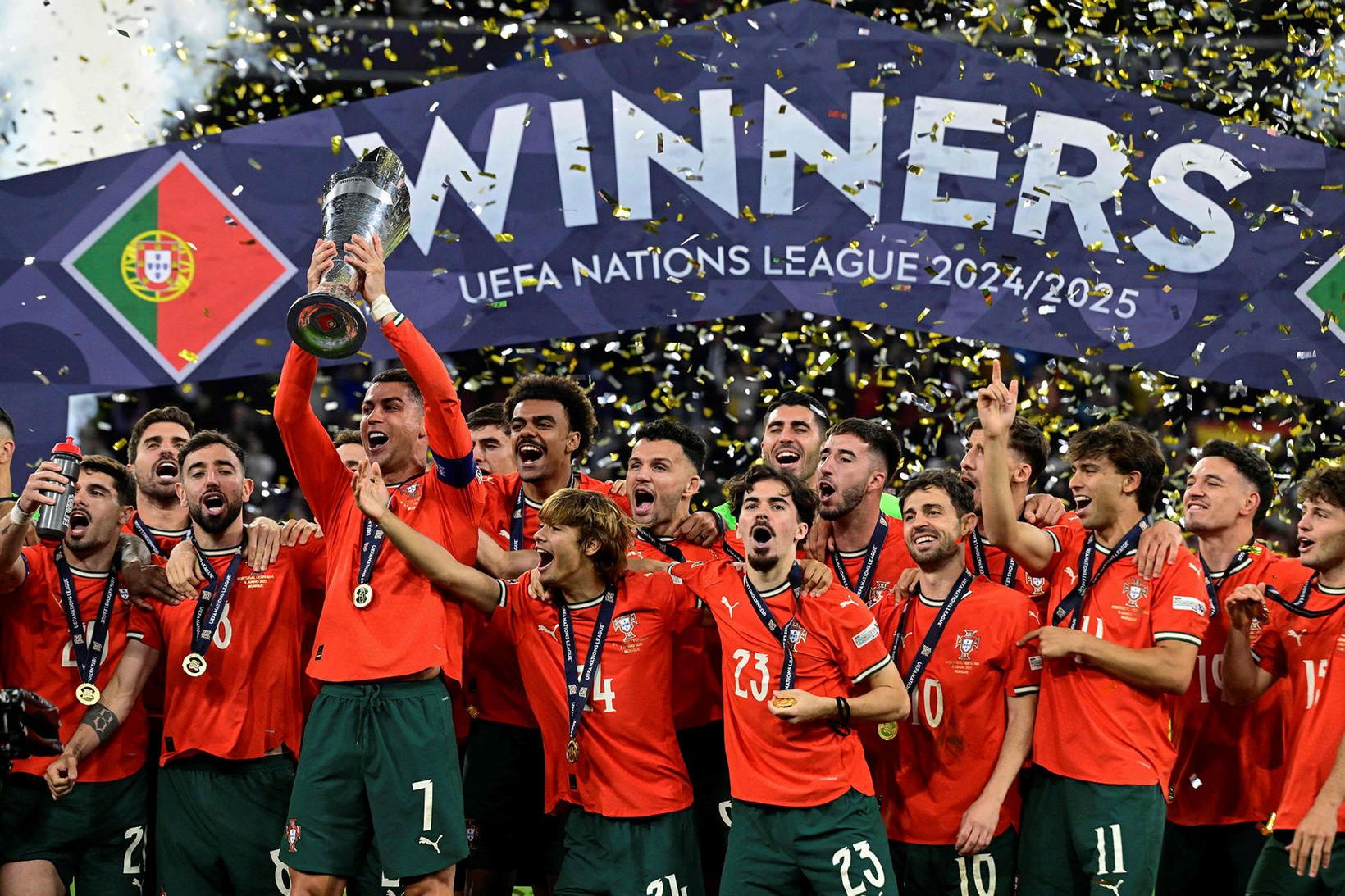 Cristiano Ronaldo fyrirliði Portúgals lyftir Þjóðadeildarbikarnum og félagar hans fagna.